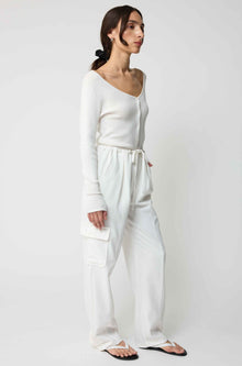 Woman wearing a white outfit against a plain background