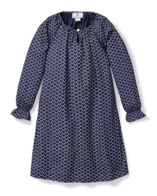 The Girls Twill Delphine Nightgown in Nordic Antlers by Petite Plume features long sleeves, a navy hue with a white scallop design, a round neckline, small front button closure, and gathered cuffs for comfort and style. Crafted from moisture-wicking twill.