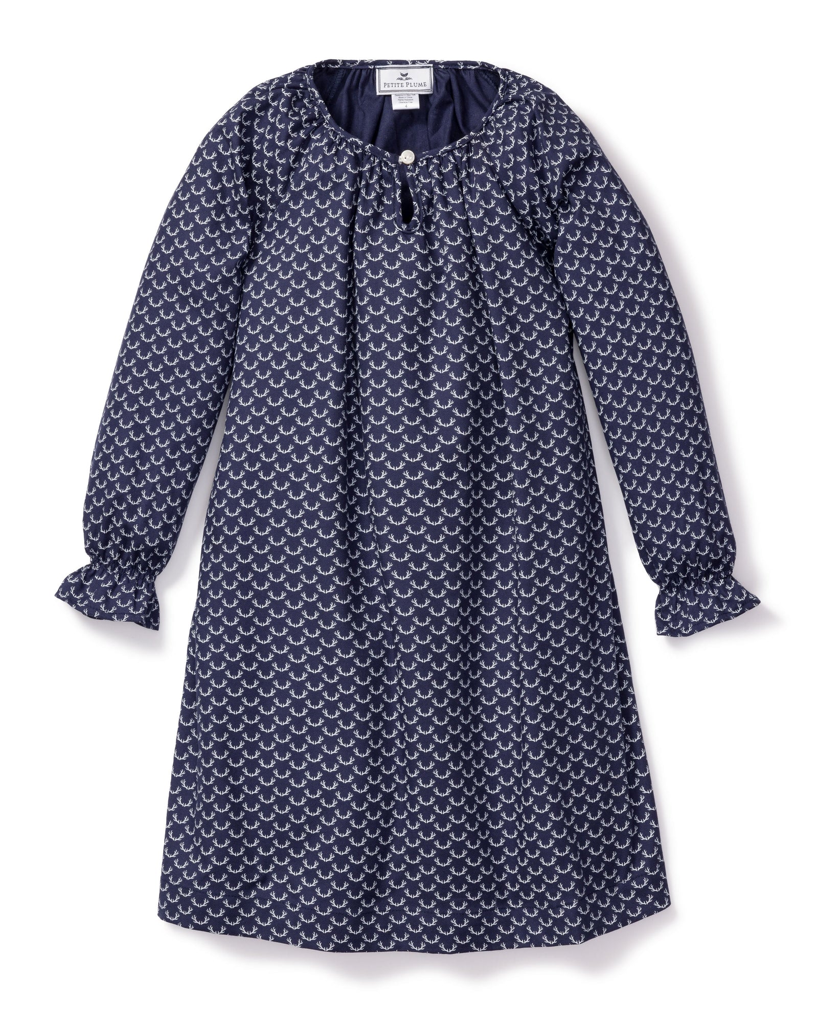 The Girls Twill Delphine Nightgown in Nordic Antlers by Petite Plume features long sleeves, a navy hue with a white scallop design, a round neckline, small front button closure, and gathered cuffs for comfort and style. Crafted from moisture-wicking twill.