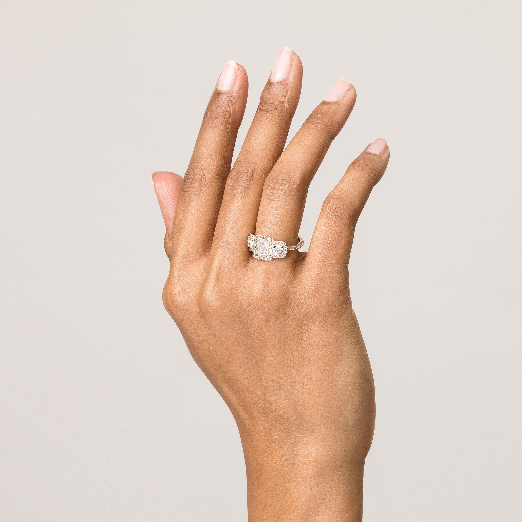 Model. Close up of hand with large engagement ring on white background