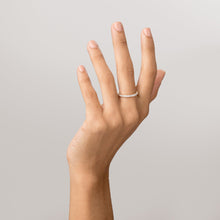 Model Close-up of a woman's hand with fingers extended upward, wearing a gold diamond eternity ring against a plain light background