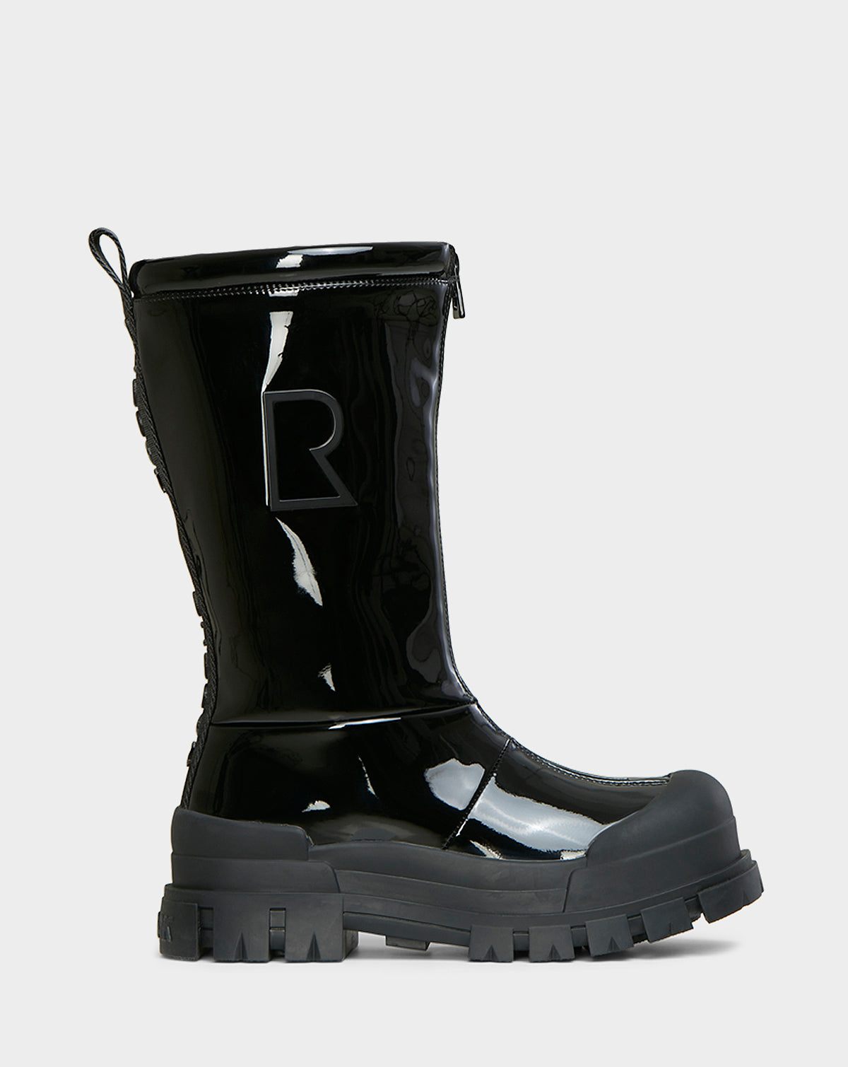 The KRISTAL HI - 8222510 BLACK by Rudsak is a womens shiny black mid-calf boot with chunky grip soles, a raised R on the side, reinforced toe and heel, and a high-gloss rugged design for lasting winter durability.