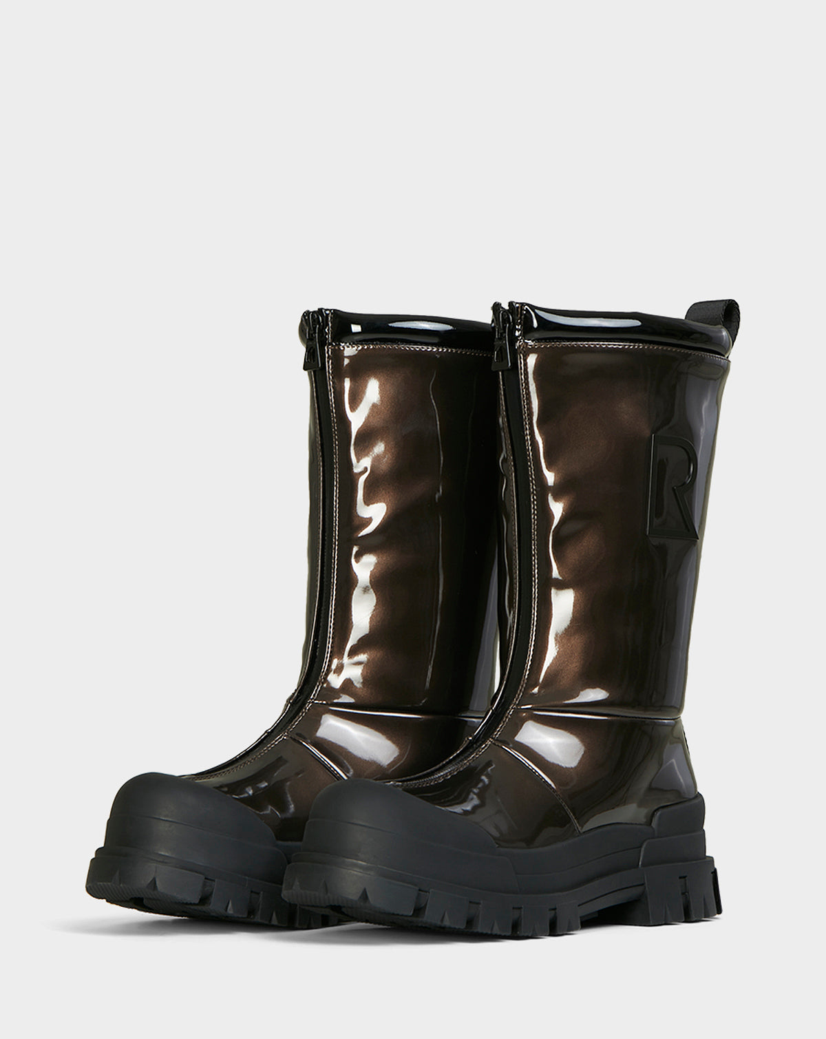 The KRISTAL HI - METALLIC CHOCOLATE boots by Rudsak are womens mid-calf winter boots featuring a glossy metallic chocolate finish, chunky grip soles, front zippers, and a raised R logo on the side.