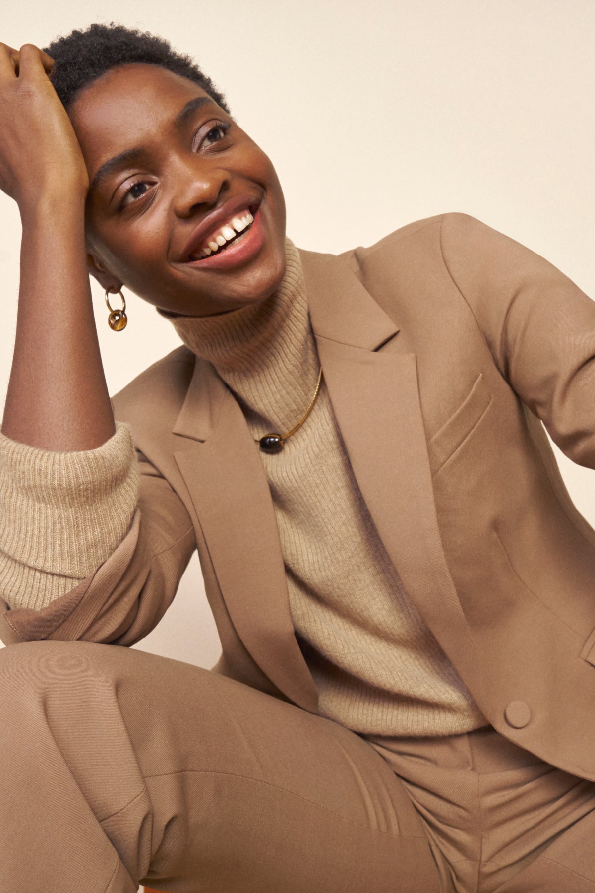 Front image of a woman standing wearing the Yiyan Blazer in Camel | Exclude