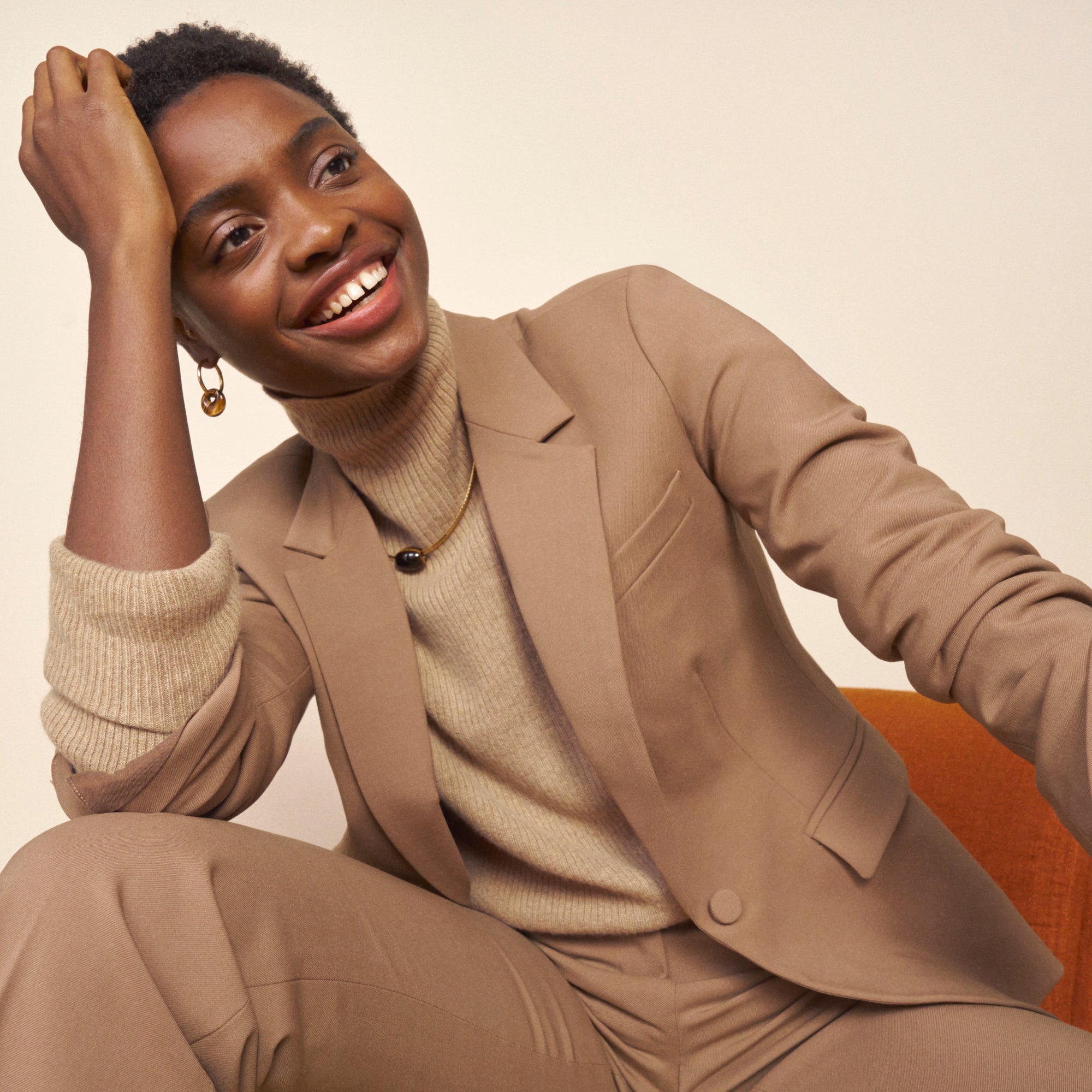 Front image of a woman standing wearing the Yiyan Blazer in Camel