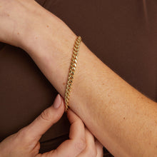 Model. Close up of woman wearing gold chain bracelet