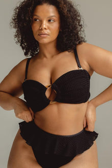 Black crochet bikini bottom with ruffled edges and textured knit fabric.