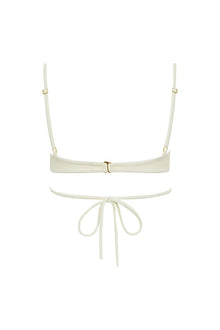 Cream bikini top with adjustable shoulder straps, center buckle closure, and tie-front bottom detail.