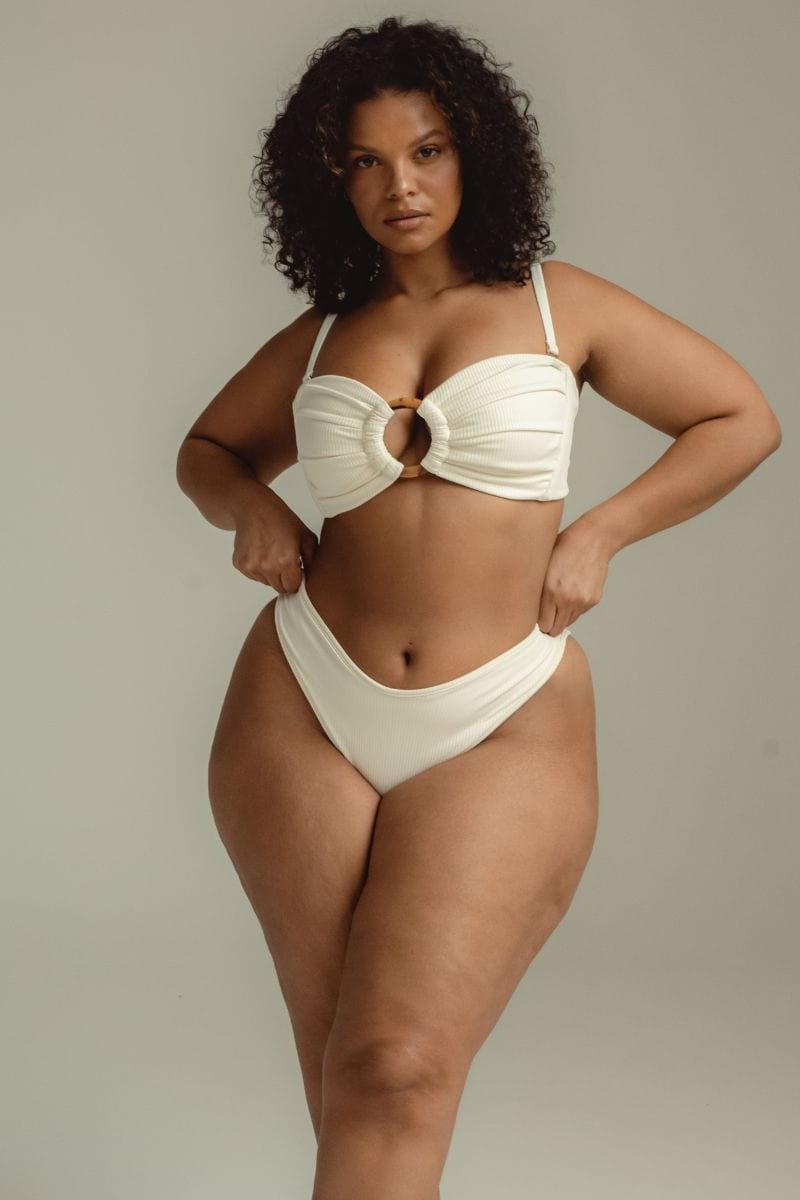 Cream ribbed bikini bottom with wide waistband, shown on model.