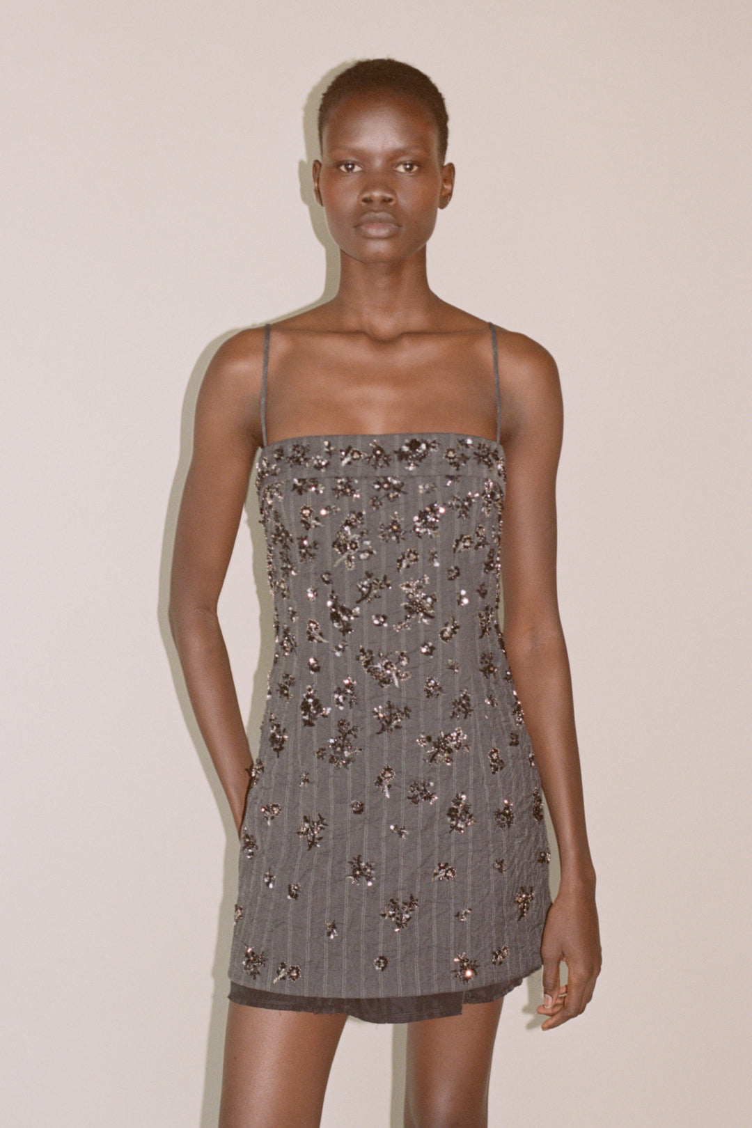 Gray mini dress with scattered beaded embellishments and thin shoulder straps.