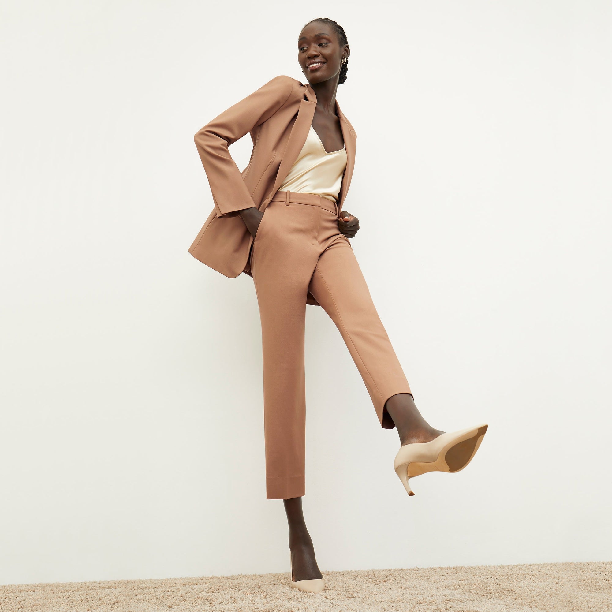 Front image of a woman standing wearing the Yiyan Blazer in Camel | Exclude
