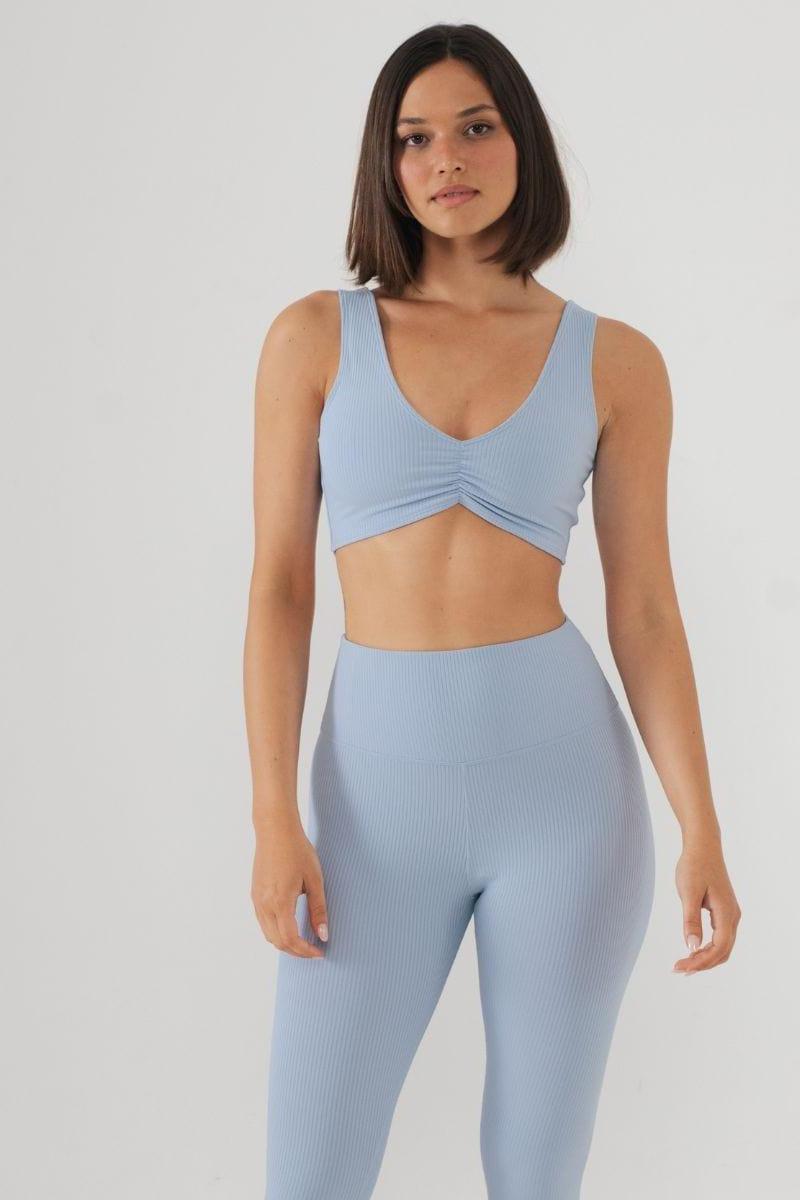 Light blue ribbed bikini top with V-neckline and twisted front detail, worn with matching high-waisted bottoms.