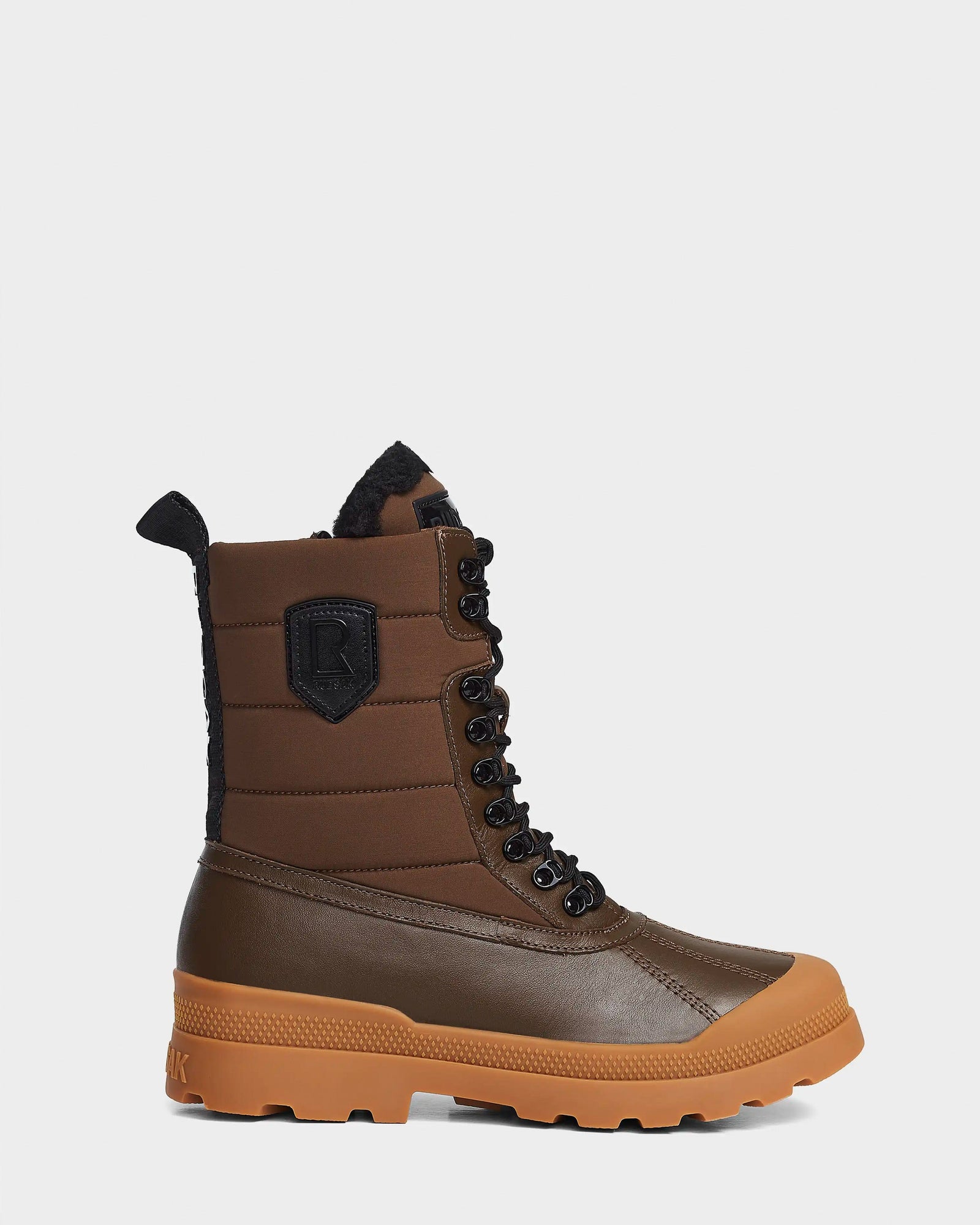 The Rudsak REAGAN - 6222500 Army is a men’s winter boot in brown leather with a rugged rubber sole, padded upper, black laces, rear pull tab, black patch, and reinforced toe and heel for added protection.