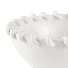 Close-up of a white ceramic bowl with textured rim on a white background