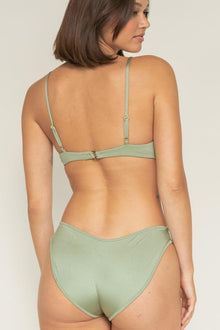 Sage green ribbed bikini bottom with moderate coverage, shown from back on model wearing matching top.