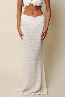 White ribbed maxi skirt with high waist and textured knit fabric.