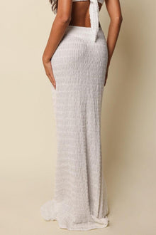 White textured maxi skirt with high waistband shown on model from side angle.