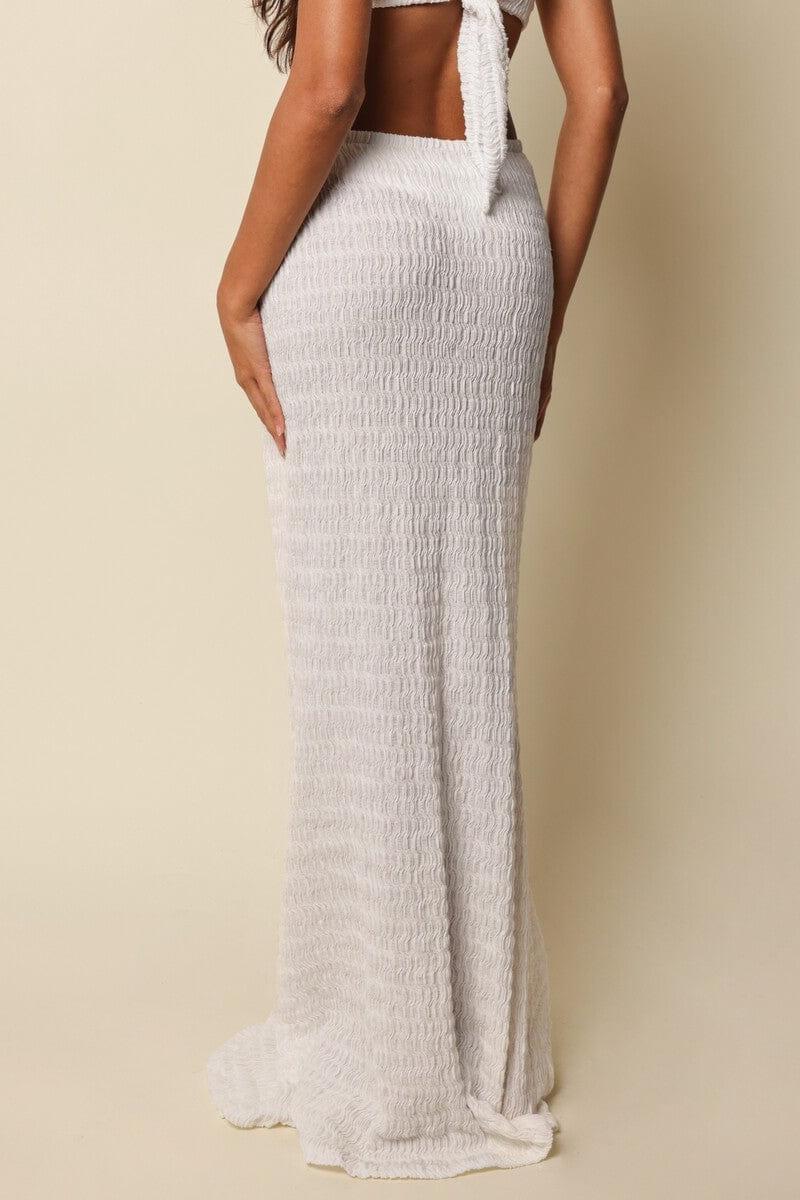 White textured maxi skirt with high waistband shown on model from side angle.
