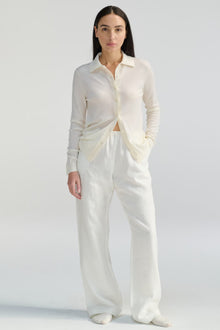 Woman wearing a white outfit on a plain background