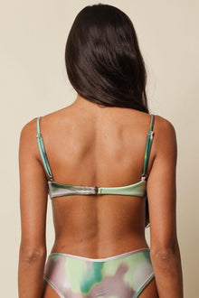 Green and pink tie-dye bikini top with thin straps and hook-and-eye back closure, shown on model from behind.