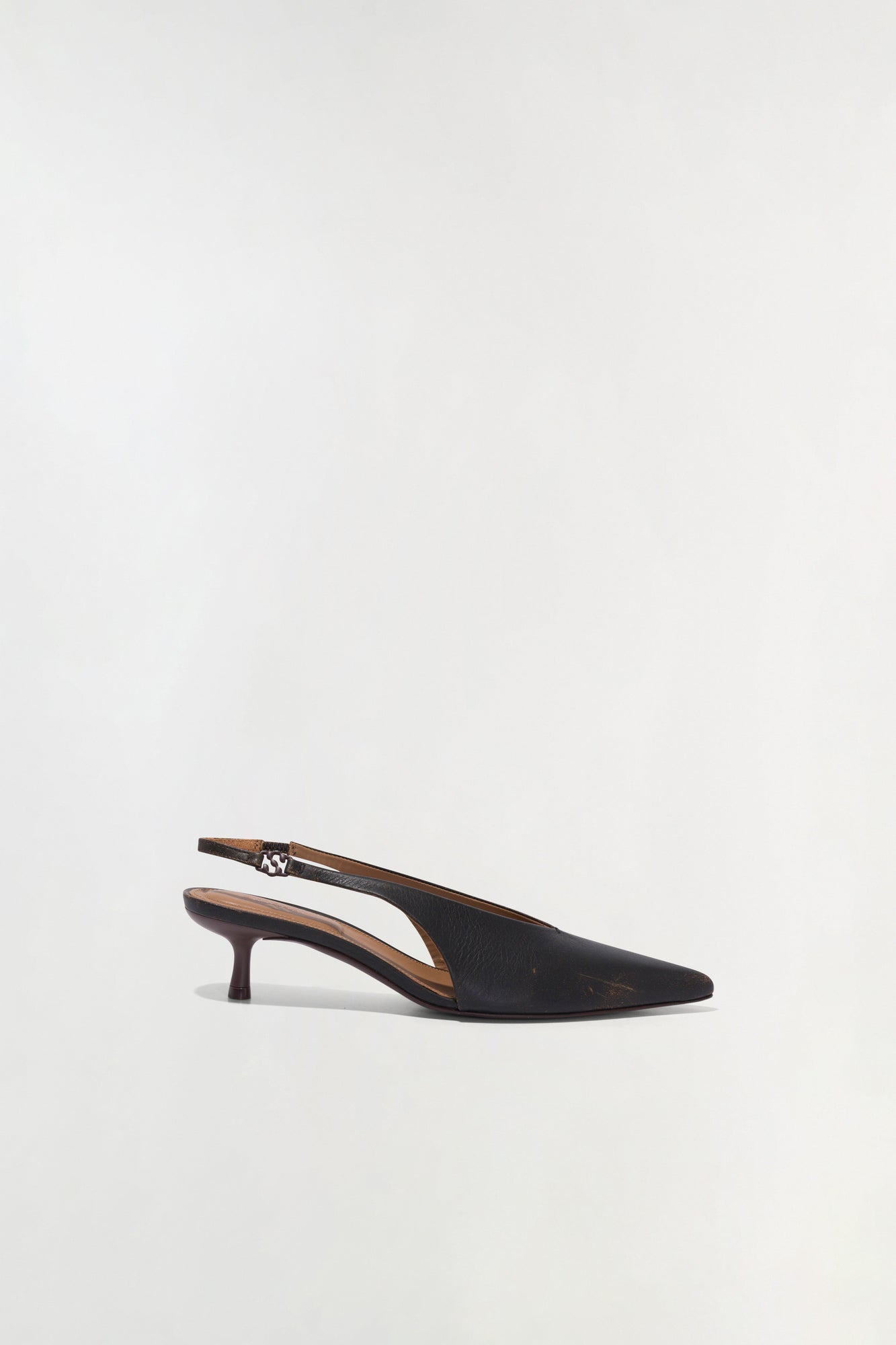 Black leather slingback kitten heel with pointed toe and adjustable ankle strap.