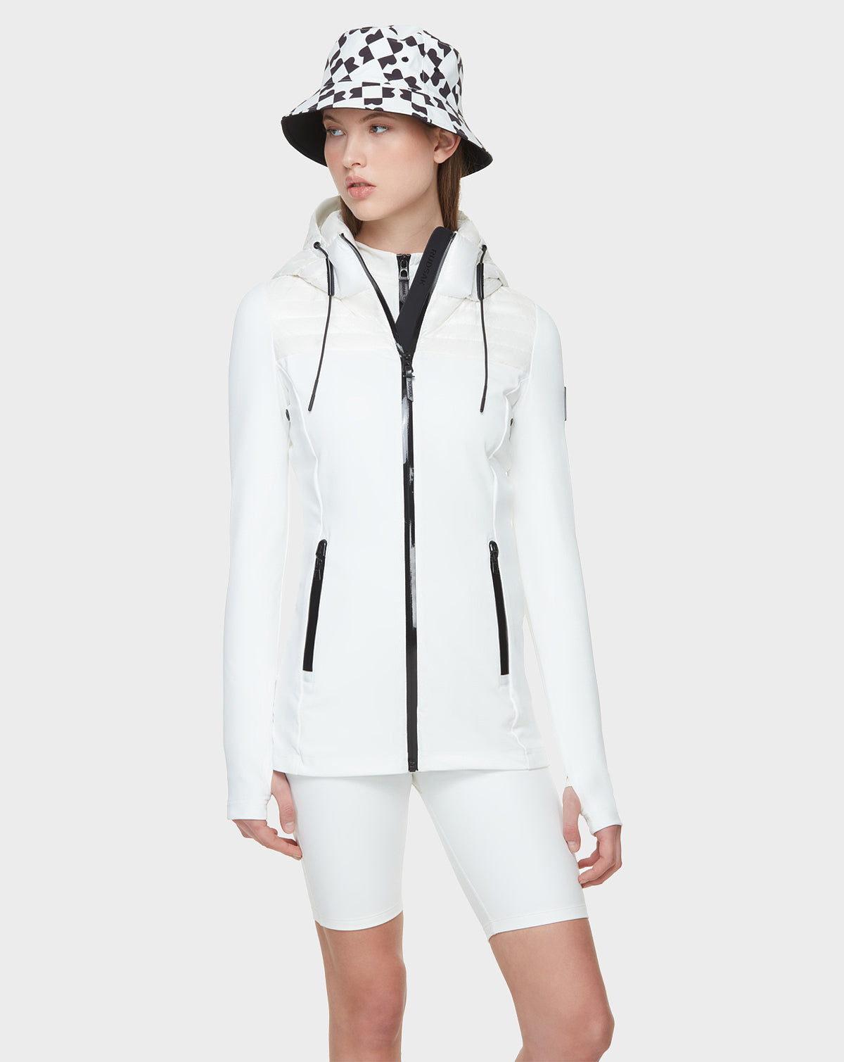 A woman wearing the CAMIRA - 8122011 WHITE jacket and shorts by Rudsak, ideal for outdoor workouts.