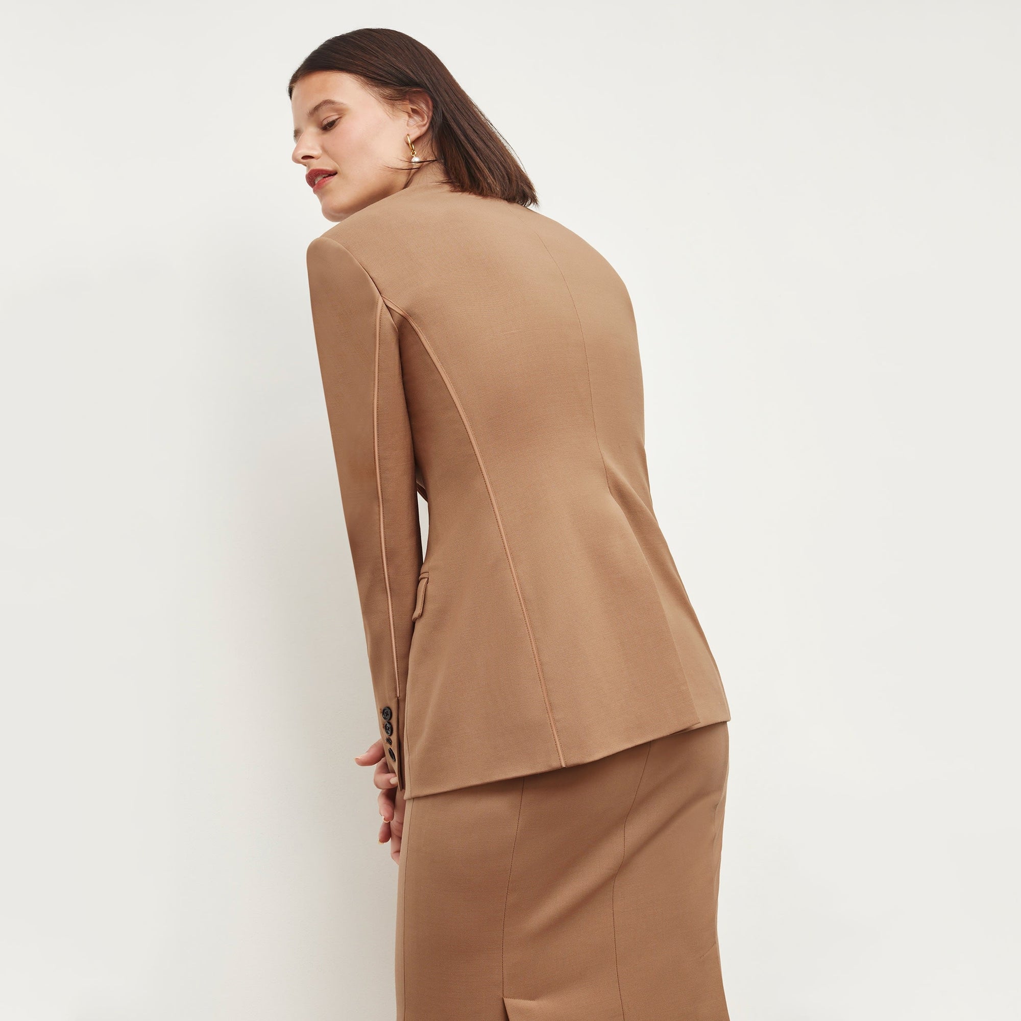 Back image of a woman standing wearing the Yiyan Blazer in Camel | Exclude