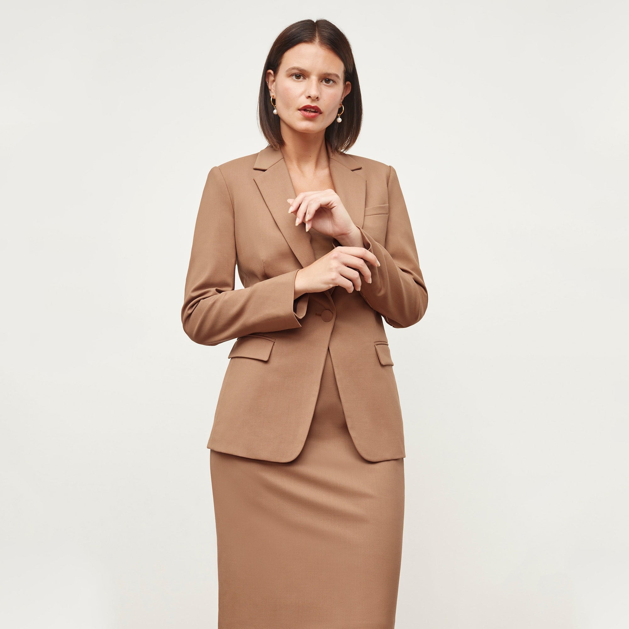 Front image of a woman standing wearing the Yiyan Blazer in Camel | Exclude