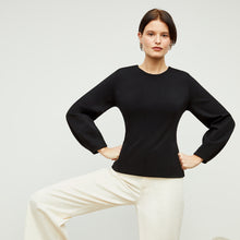 Front image of a woman standing wearing the rashida top in black | Lead