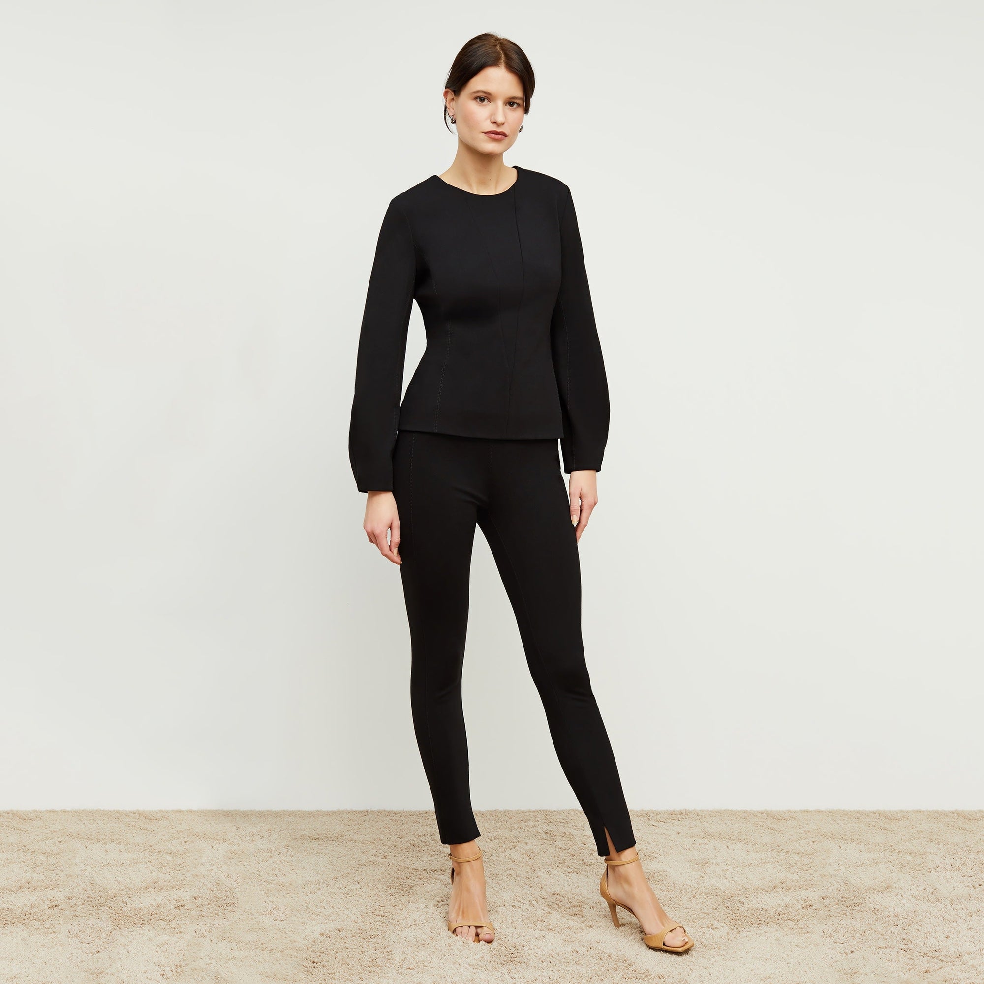 Front image of a woman standing wearing the rashida top in black