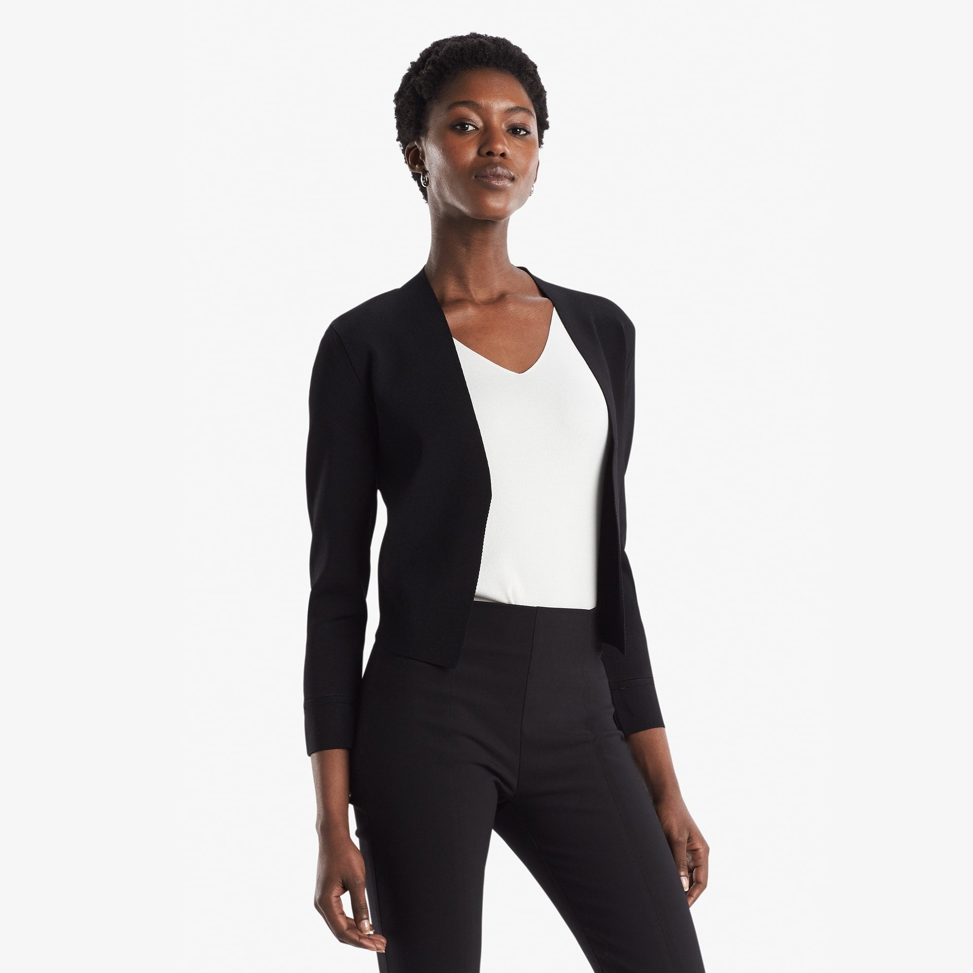 Side image of a woman standing wearing the Sant Ambroeus jardigan in black | Exclude